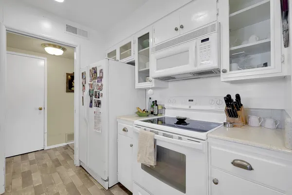 a kitchen with stainless steel appliances white cabinets and a refrigerator