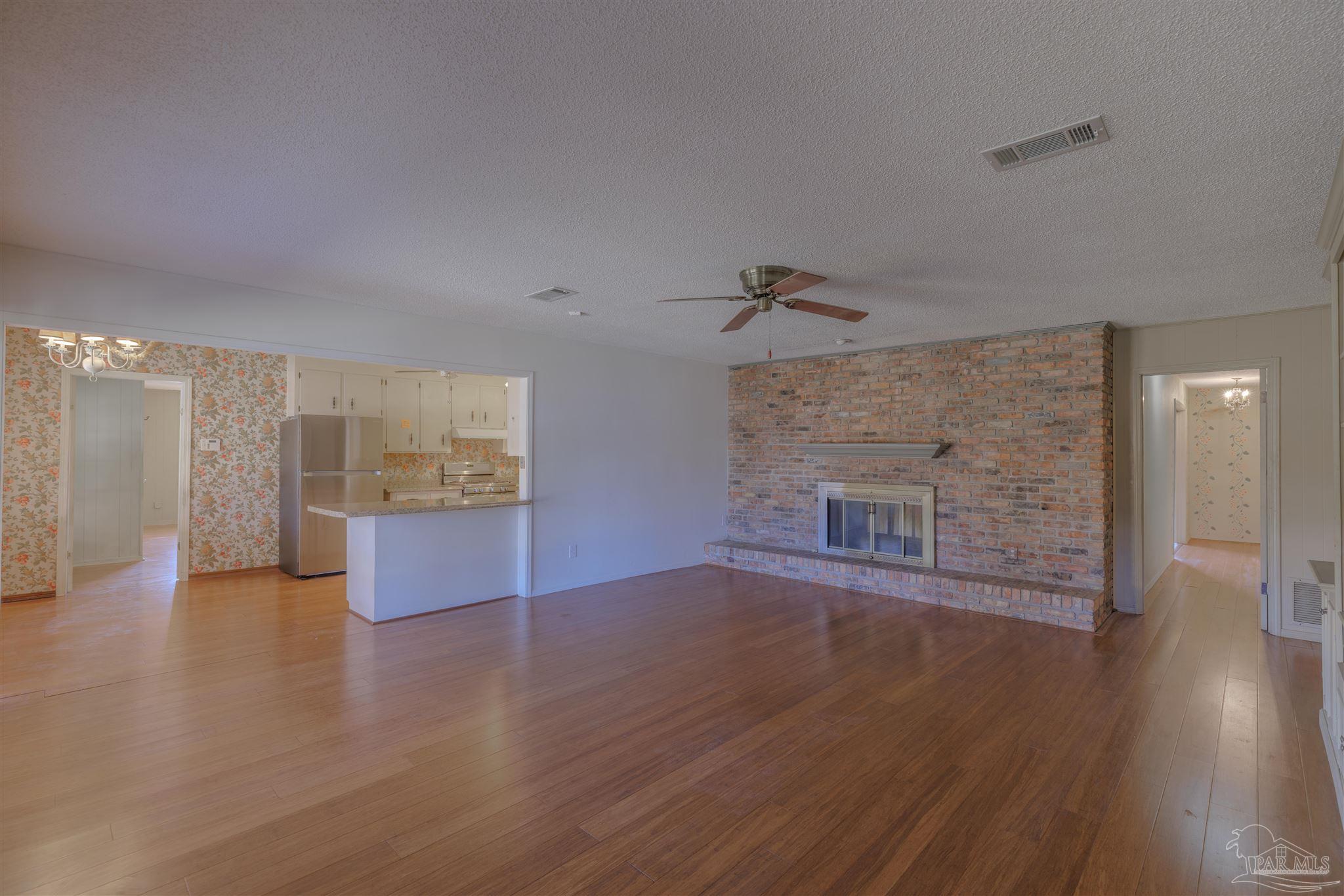 5700 Adelyn Road Pensacola, FL 32504 - Photo 11 of 33 a view of empty room with wooden floor and fireplace
