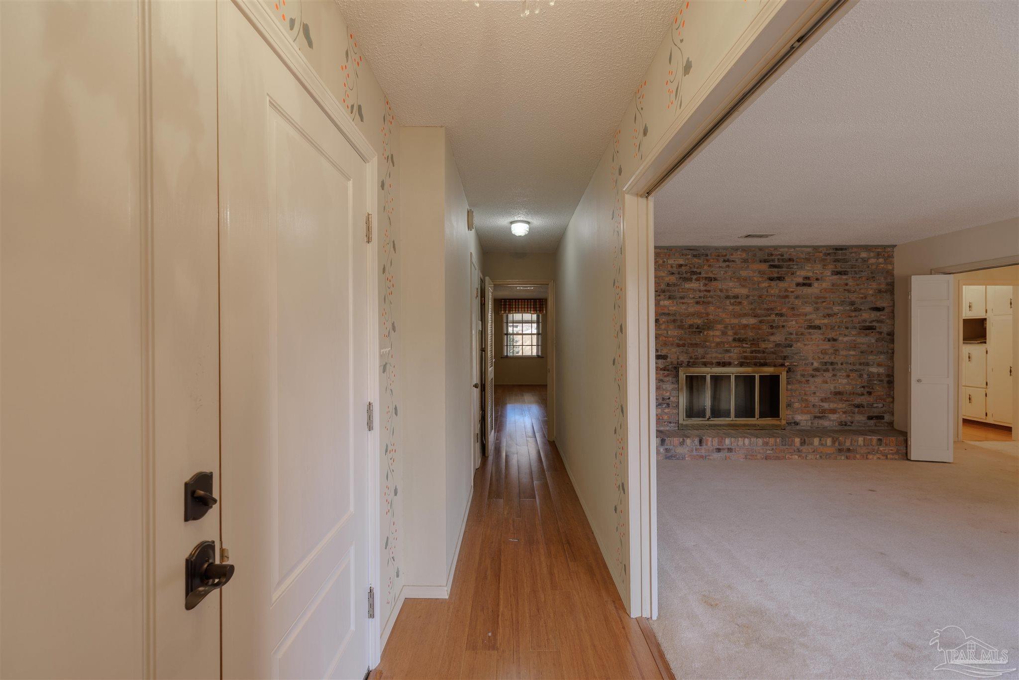 5700 Adelyn Road Pensacola, FL 32504 - Photo 3 of 33 a view of a hallway with wooden floor and a fireplace