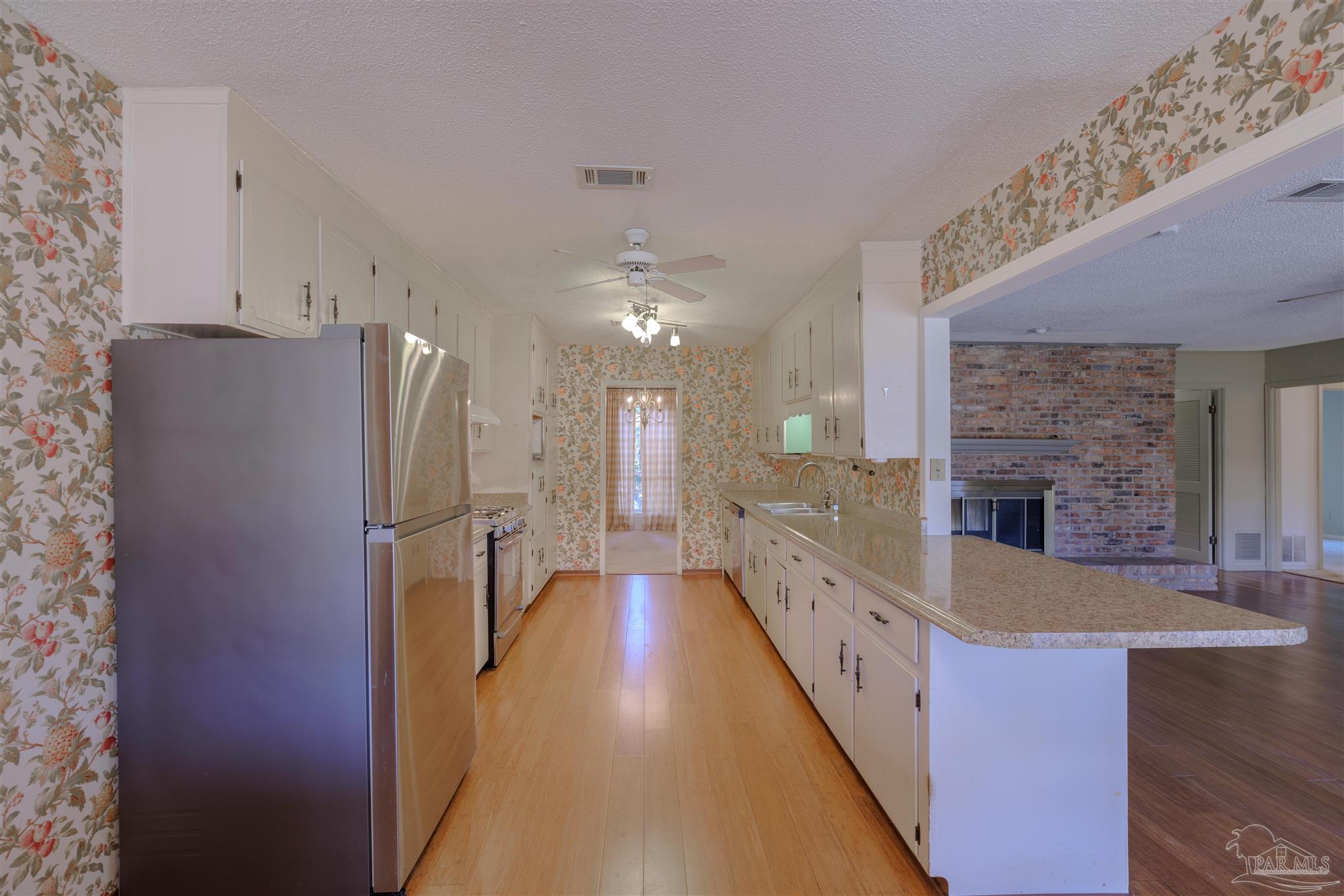5700 Adelyn Road Pensacola, FL 32504 - Photo 9 of 33 a large kitchen with a large counter top and stainless steel appliances