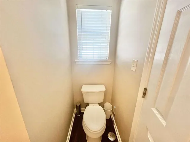 a view of a white house with a large windows and a yard with plants