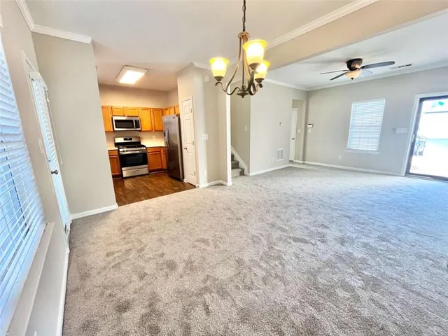 a kitchen with granite countertop a refrigerator a sink dishwasher stove and oven with wooden floor