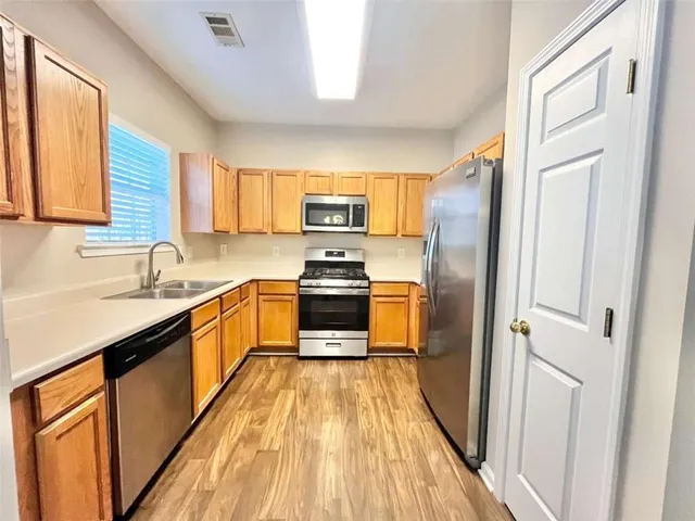 a kitchen with stainless steel appliances granite countertop a refrigerator and a stove