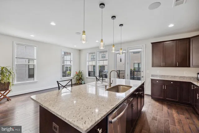 a kitchen with granite countertop a sink a counter space appliances and cabinets