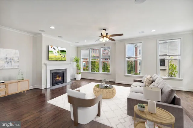 a living room with fireplace furniture and a large window