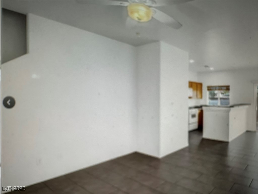5512 East Jackpot Winner Lane, Unit 102 Las Vegas, NV 89122 - Photo 11 of 15 Unfurnished living room with a ceiling fan and dark tile patterned floors