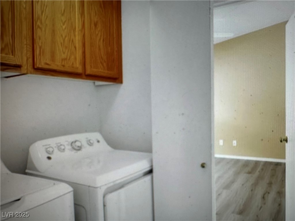 5512 East Jackpot Winner Lane, Unit 102 Las Vegas, NV 89122 - Photo 12 of 15 Laundry area featuring washing machine and dryer, wood finished floors, and cabinet space