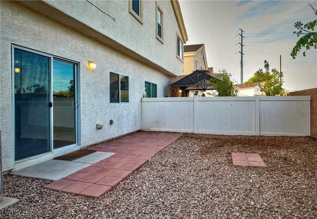 5512 East Jackpot Winner Lane, Unit 102 Las Vegas, NV 89122 - Photo 14 of 15 Yard at dusk with a fenced backyard and a patio area