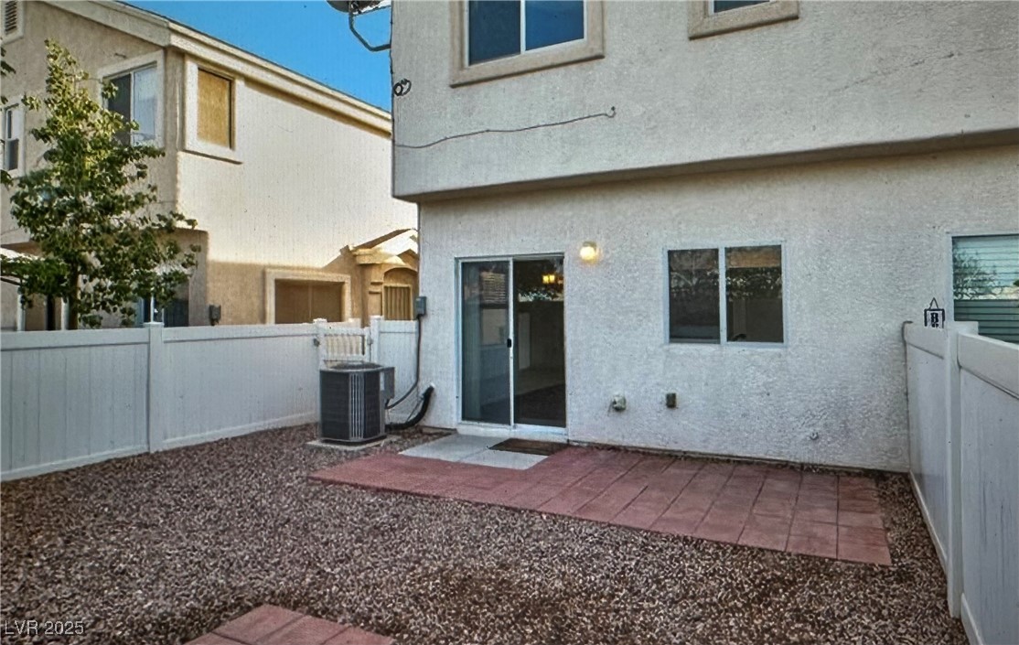 5512 East Jackpot Winner Lane, Unit 102 Las Vegas, NV 89122 - Photo 15 of 15 Rear view of house featuring stucco siding, a fenced backyard, and a patio