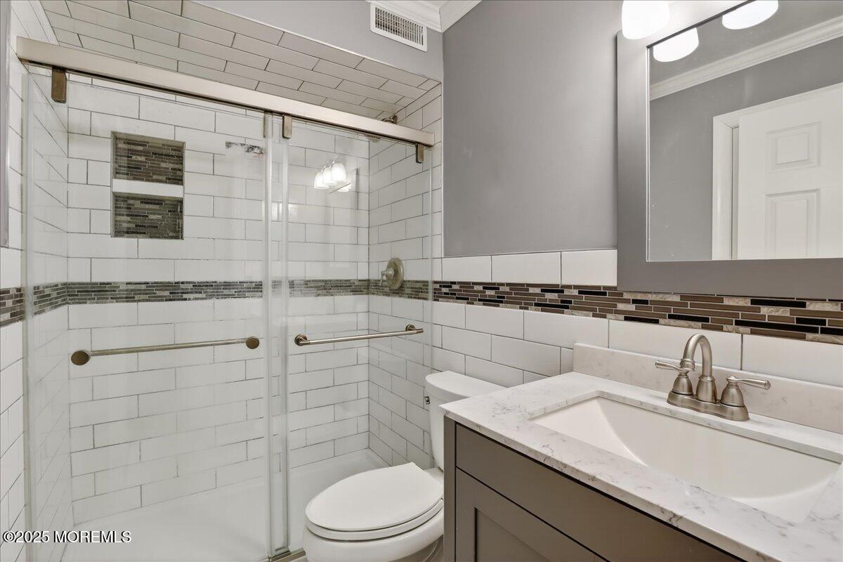 53 Sweet Gum Road Howell, NJ 07731 - Photo 31 of 62 a bathroom with a granite countertop sink a toilet a mirror and shower