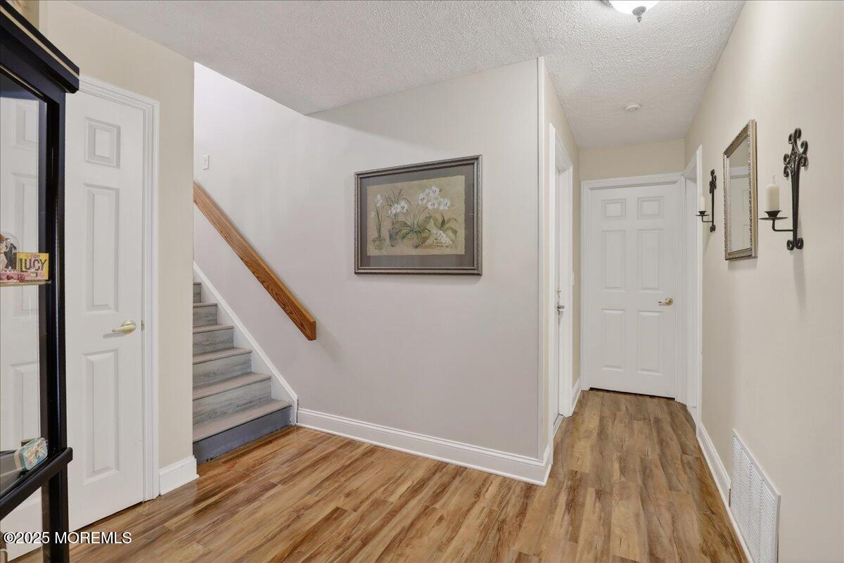 53 Sweet Gum Road Howell, NJ 07731 - Photo 33 of 62 a view of a hallway with wooden floor and staircase