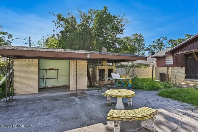 a view of a patio with table chairs and a potted plants