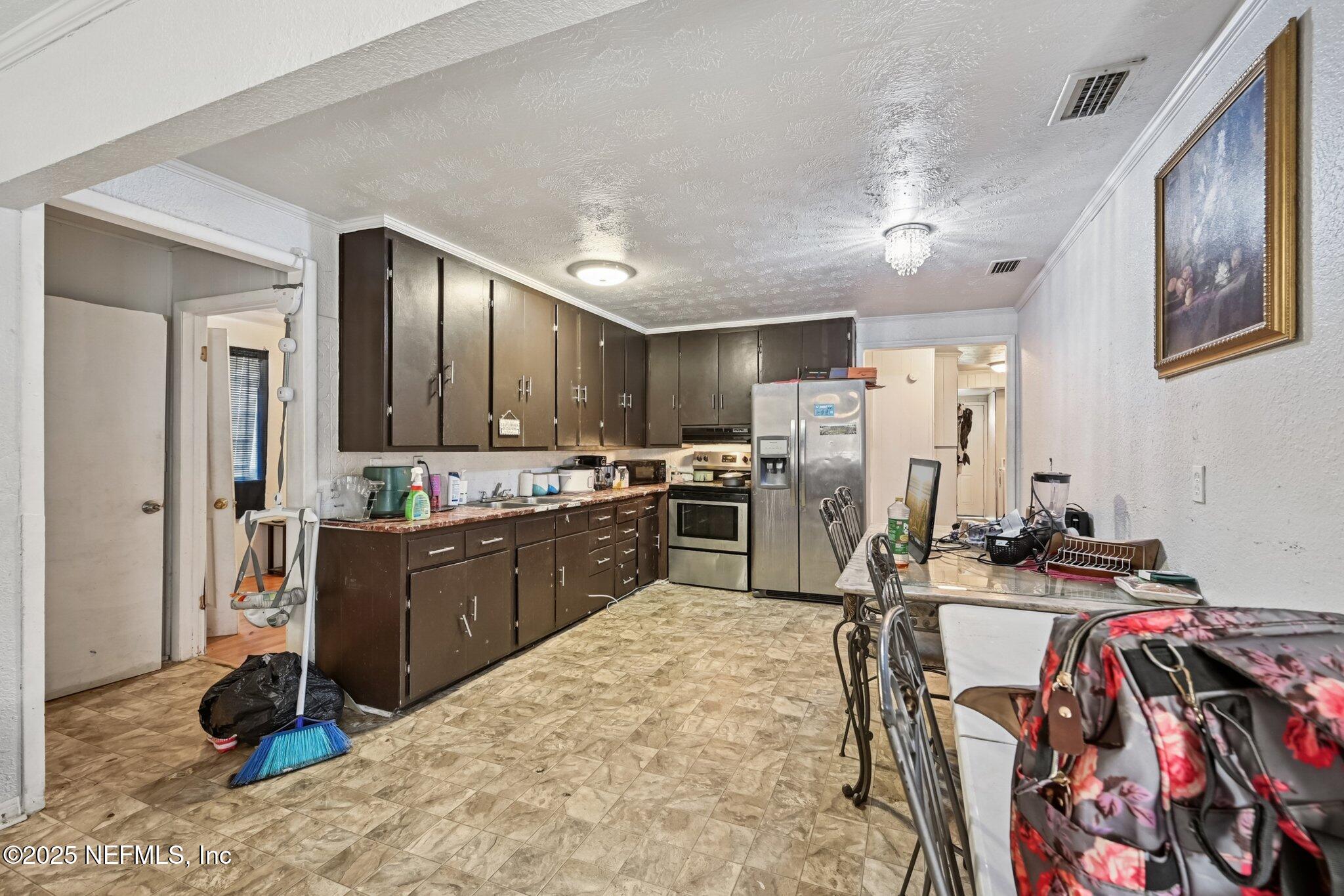 5635 Atlee Avenue Jacksonville, FL 32205 - Photo 9 of 31 a kitchen with stainless steel appliances kitchen island granite countertop a refrigerator and a sink