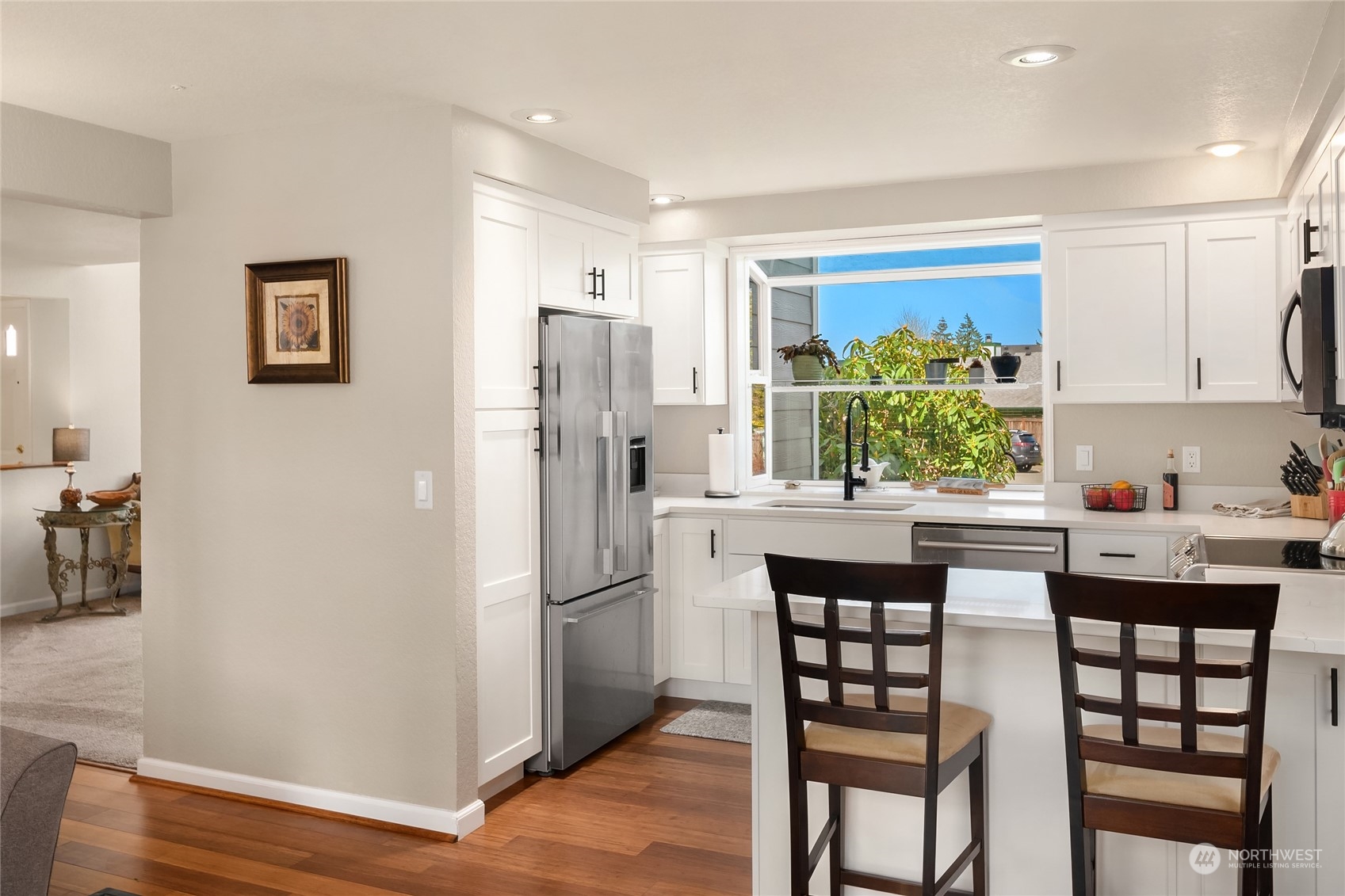23530 22nd Avenue Southeast Bothell, WA 98021 - Photo 11 of 30 a kitchen with stainless steel appliances a dining table chairs and refrigerator