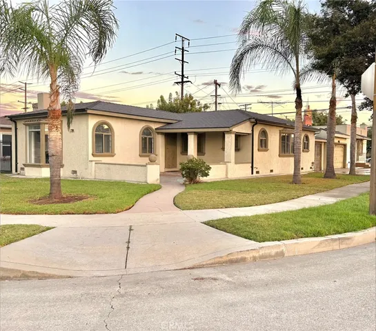 a front view of a house with garden and plants