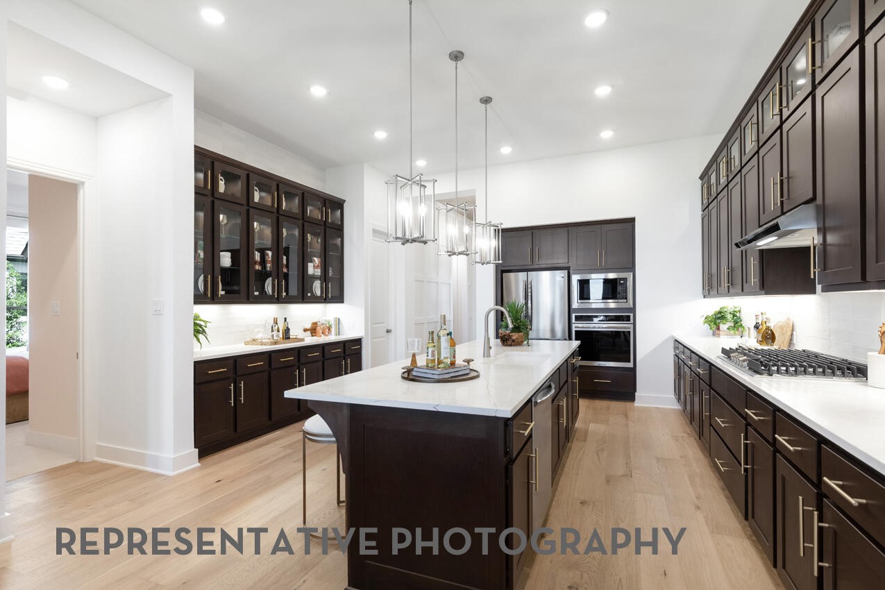 18918 Moonriver Street Conroe, TX 77302 - Photo 4 of 25 a kitchen with granite countertop a sink cabinets and wooden floor