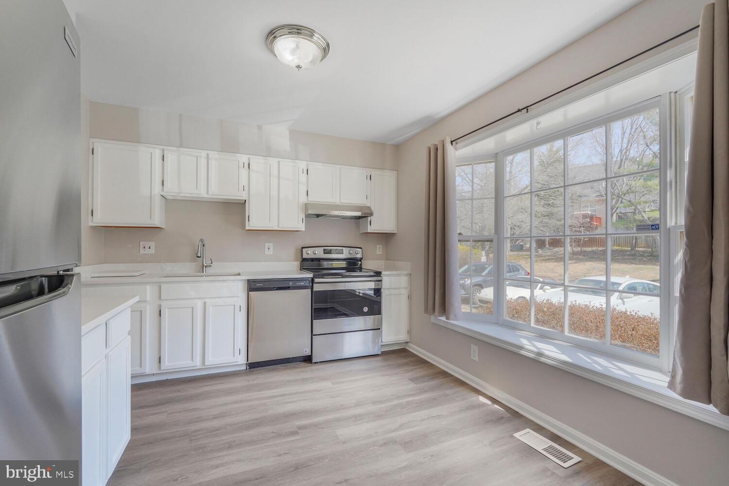 a kitchen with granite countertop a stove top oven sink and cabinets
