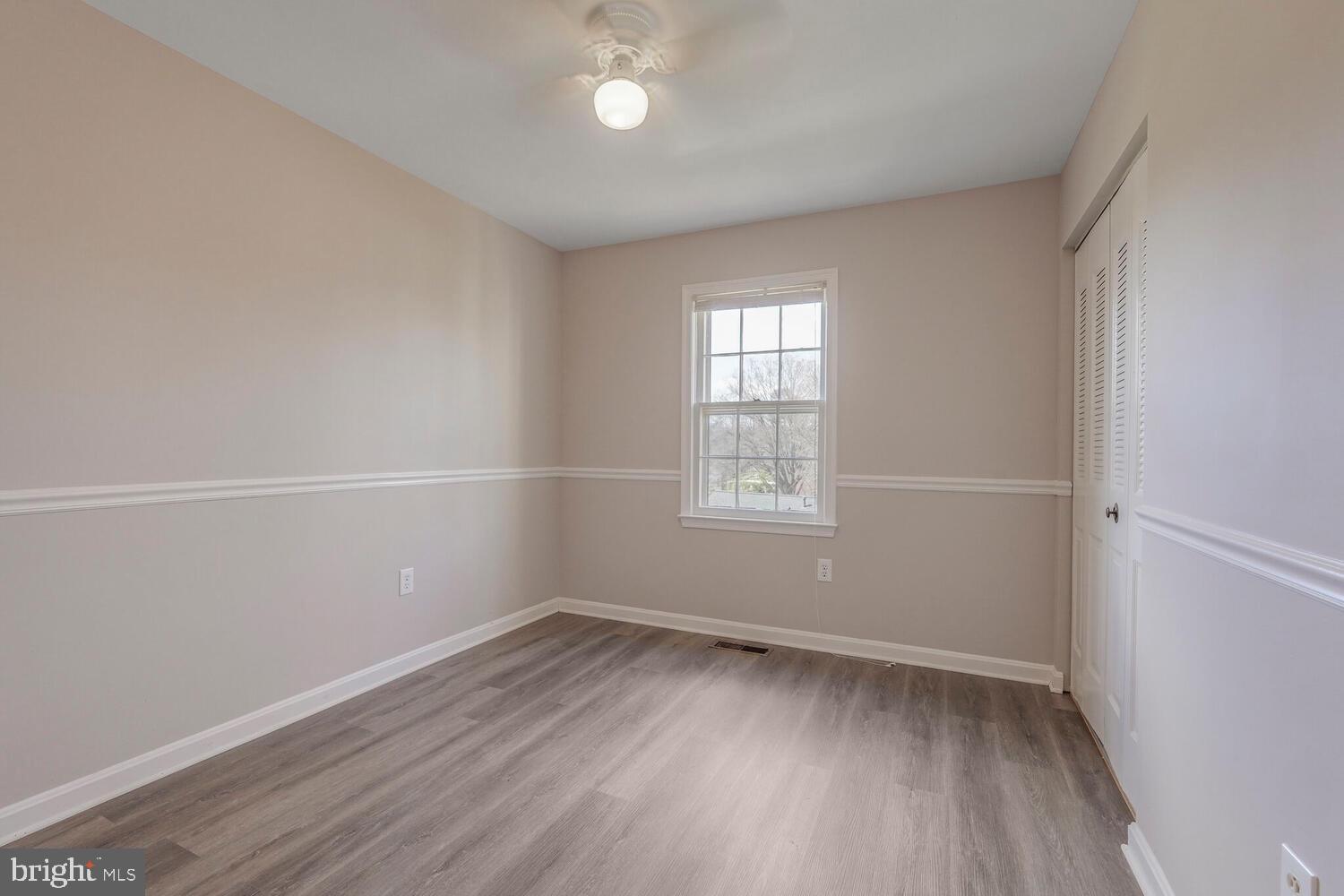 7314 Eggar Woods Lane Springfield, VA 22153 - Photo 14 of 23 an empty room with wooden floor and windows