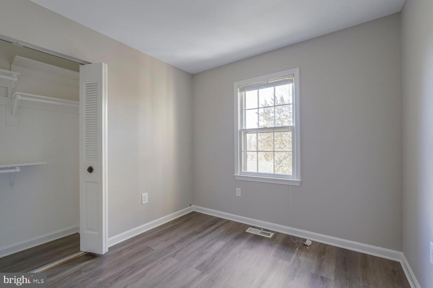 7314 Eggar Woods Lane Springfield, VA 22153 - Photo 15 of 23 an empty room with wooden floor and windows