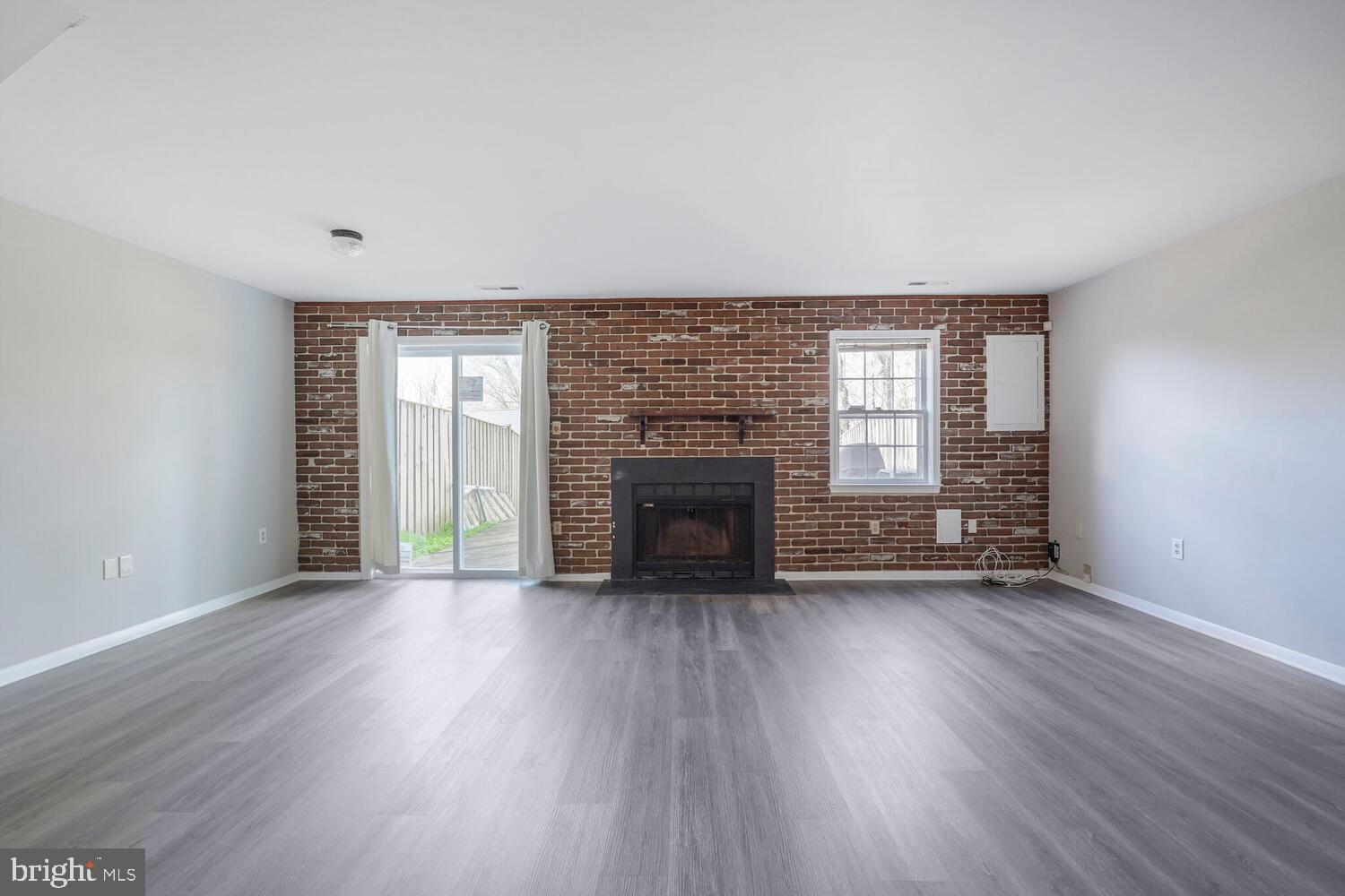 7314 Eggar Woods Lane Springfield, VA 22153 - Photo 17 of 23 an empty room with wooden floor fireplace and windows