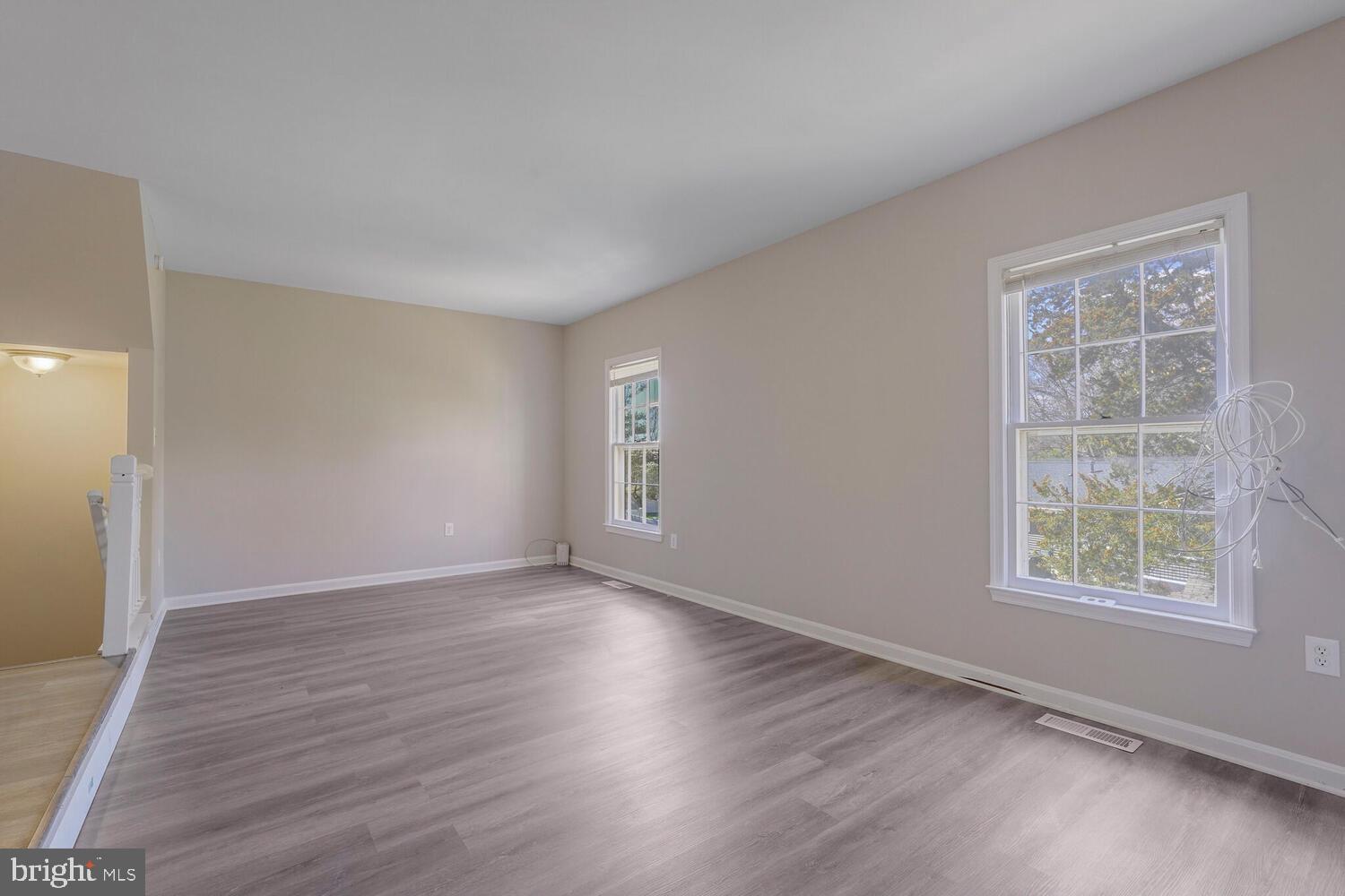 7314 Eggar Woods Lane Springfield, VA 22153 - Photo 8 of 23 an empty room with wooden floor and windows