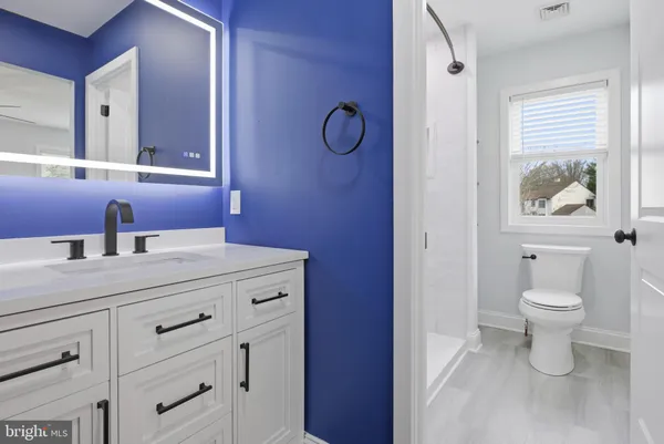 a bathroom with a toilet a sink and mirror