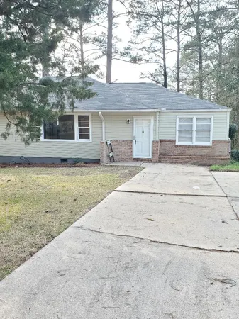 a front view of a house with a garden and yard