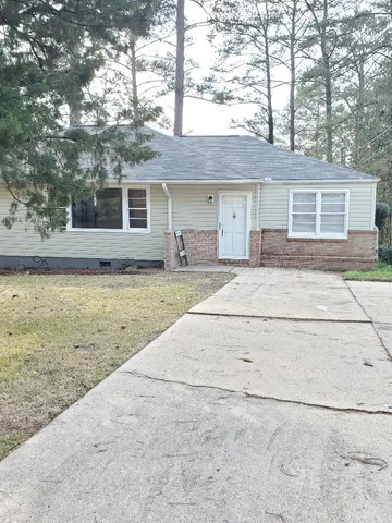 a front view of a house with a garden and yard