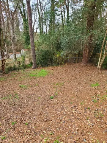 a view of a house with a yard and the trees