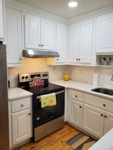 a kitchen with stainless steel appliances granite countertop a sink stove and cabinets