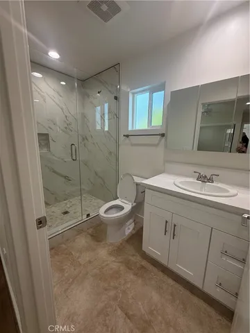 a bathroom with a double vanity sink toilet and shower