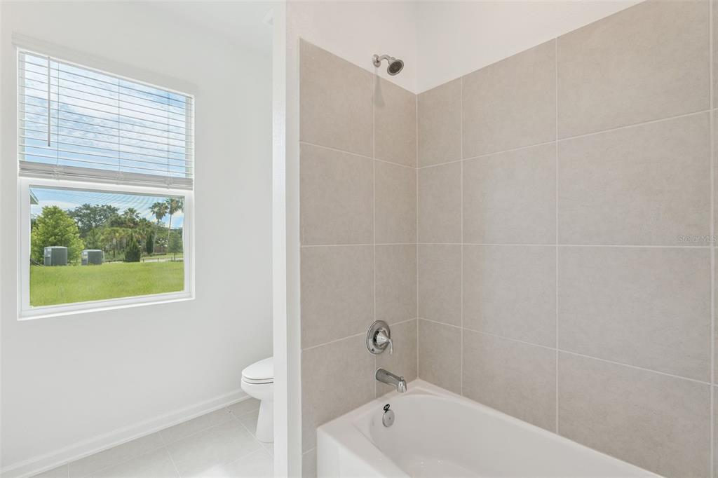 1672 Rider Rain Lane Apopka, FL 32703 - Photo 28 of 35 a bathroom with a bathtub and window