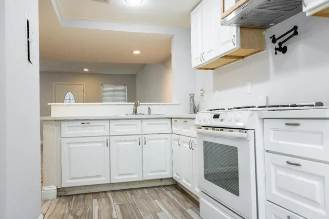 a kitchen with white cabinets and white appliances