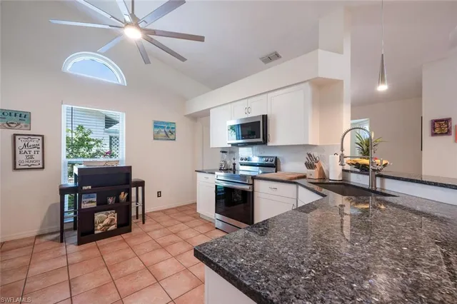 a kitchen with stainless steel appliances granite countertop a sink and cabinets