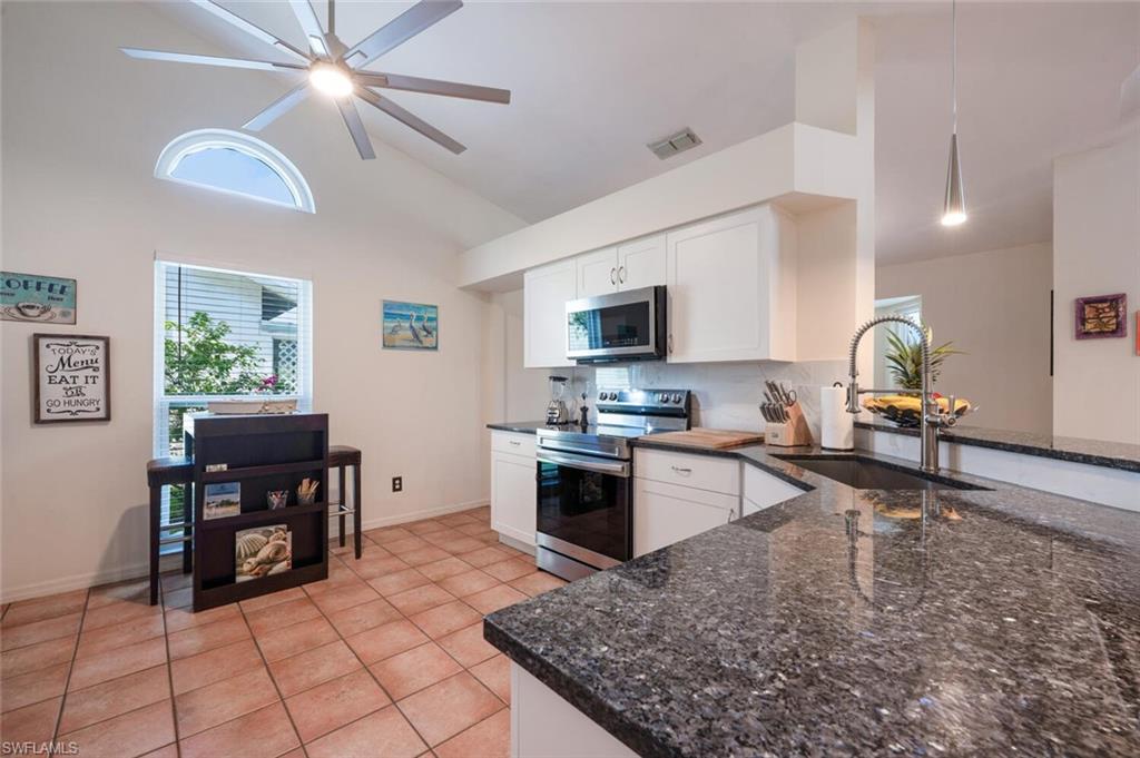 229 Countryside Drive Naples, FL 34104 - Photo 11 of 44 a open kitchen with stainless steel appliances granite countertop a sink dishwasher stove top oven a dining table and chairs with wooden floor