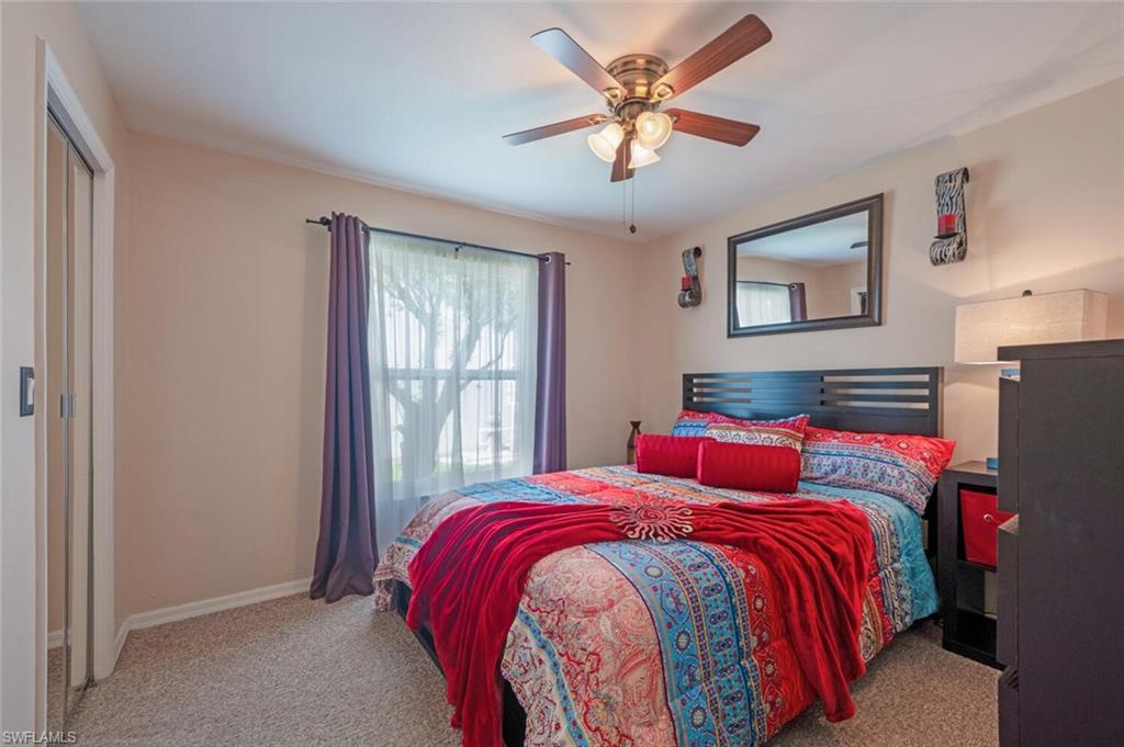 229 Countryside Drive Naples, FL 34104 - Photo 20 of 44 a bedroom with a large bed and a chandelier