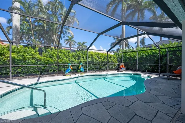 a view of a swimming pool with a patio and plants