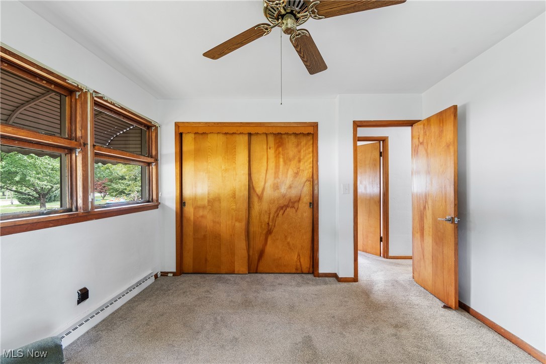 1067 Munroe Falls Kent Road Kent, OH 44240 - Photo 14 of 31 Unfurnished bedroom with a closet, a baseboard radiator, light carpet, and ceiling fan
