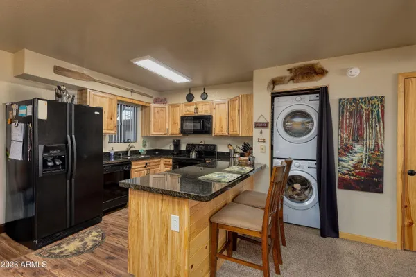 a living room with furniture kitchen view and a chandelier