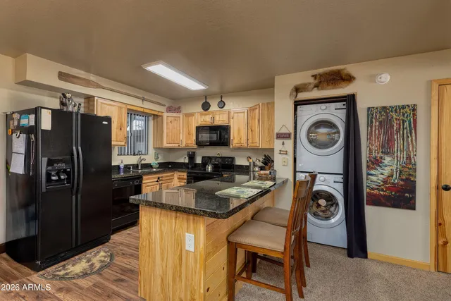 a living room with furniture kitchen view and a chandelier