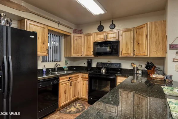a kitchen with stainless steel appliances granite countertop a refrigerator a stove and a sink