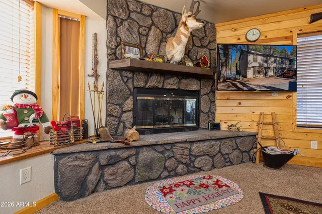 a living room with furniture a flat screen tv and a floor to ceiling window