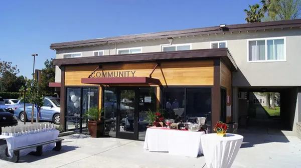 a front view of a house with yard and parking