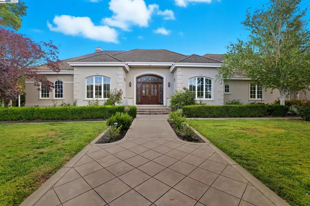 a front view of a house with yard and green space