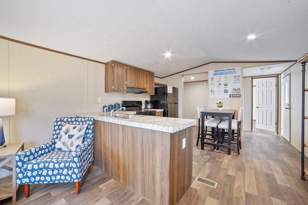 1206 Hayes Road Sherman, TX 75090 - Photo 11 of 21 a kitchen with stainless steel appliances granite countertop a stove top oven a sink dishwasher and a dining table with wooden floor