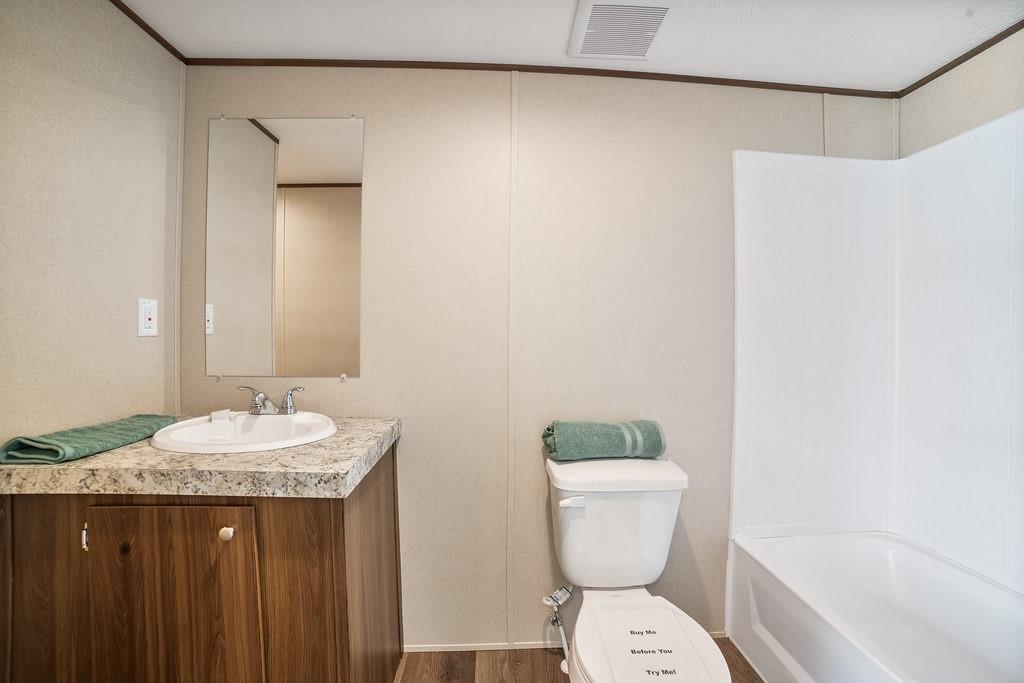1206 Hayes Road Sherman, TX 75090 - Photo 16 of 21 a bathroom with a granite countertop sink a toilet and a mirror