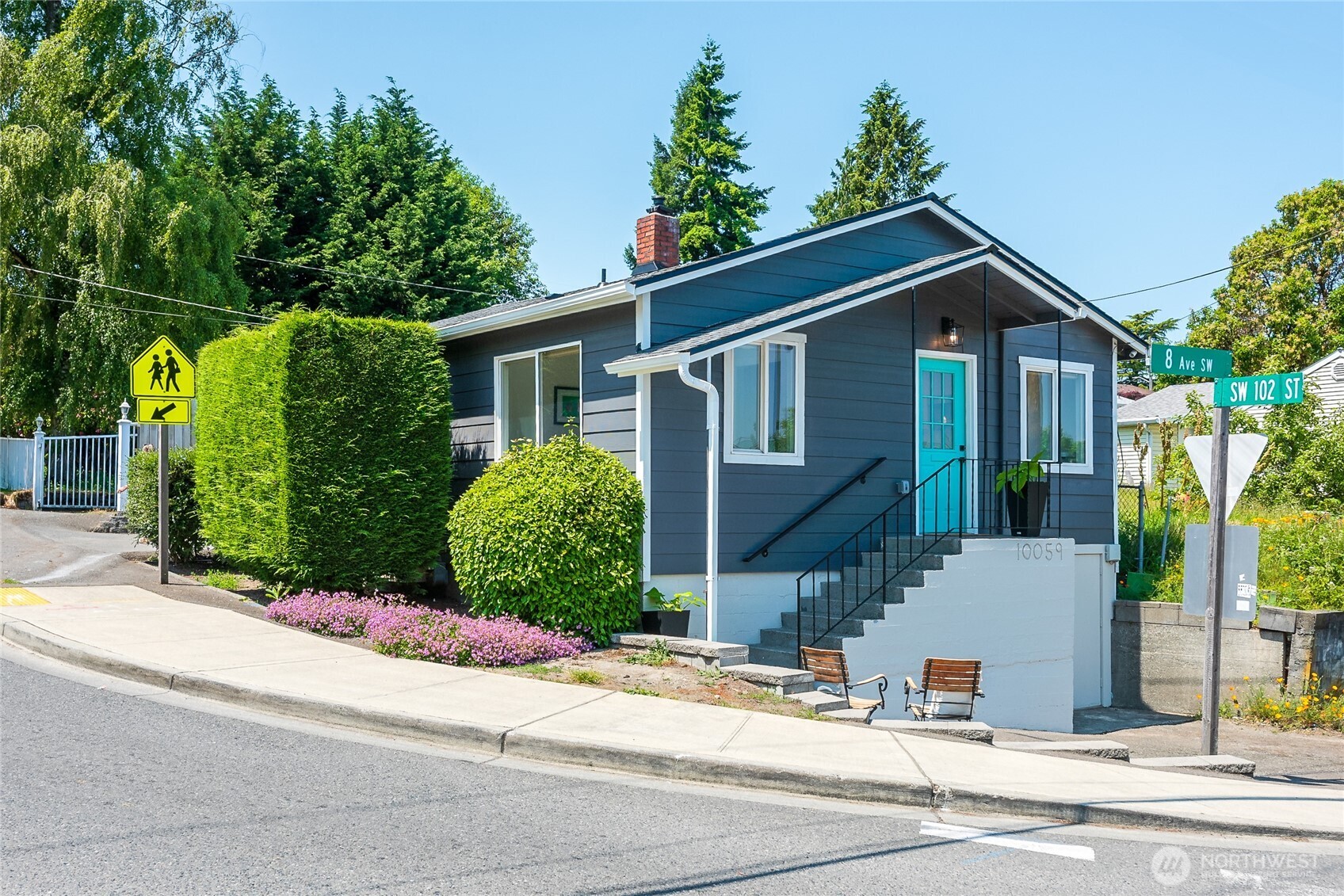 a front view of a house with a garden and plants