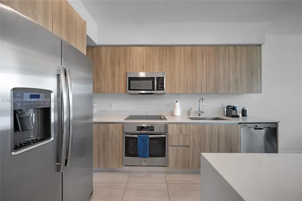 a kitchen with stainless steel appliances granite countertop a refrigerator stove a sink and dishwasher