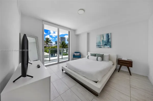 a living room with a bed furniture and a large window