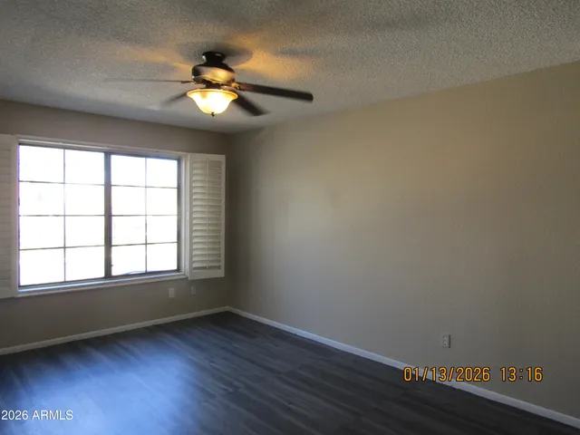 a view of wooden floor in an empty room with a window
